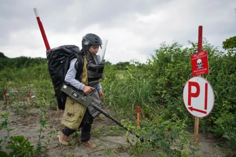 Mujer busca minas antipersonal en zonas rojas